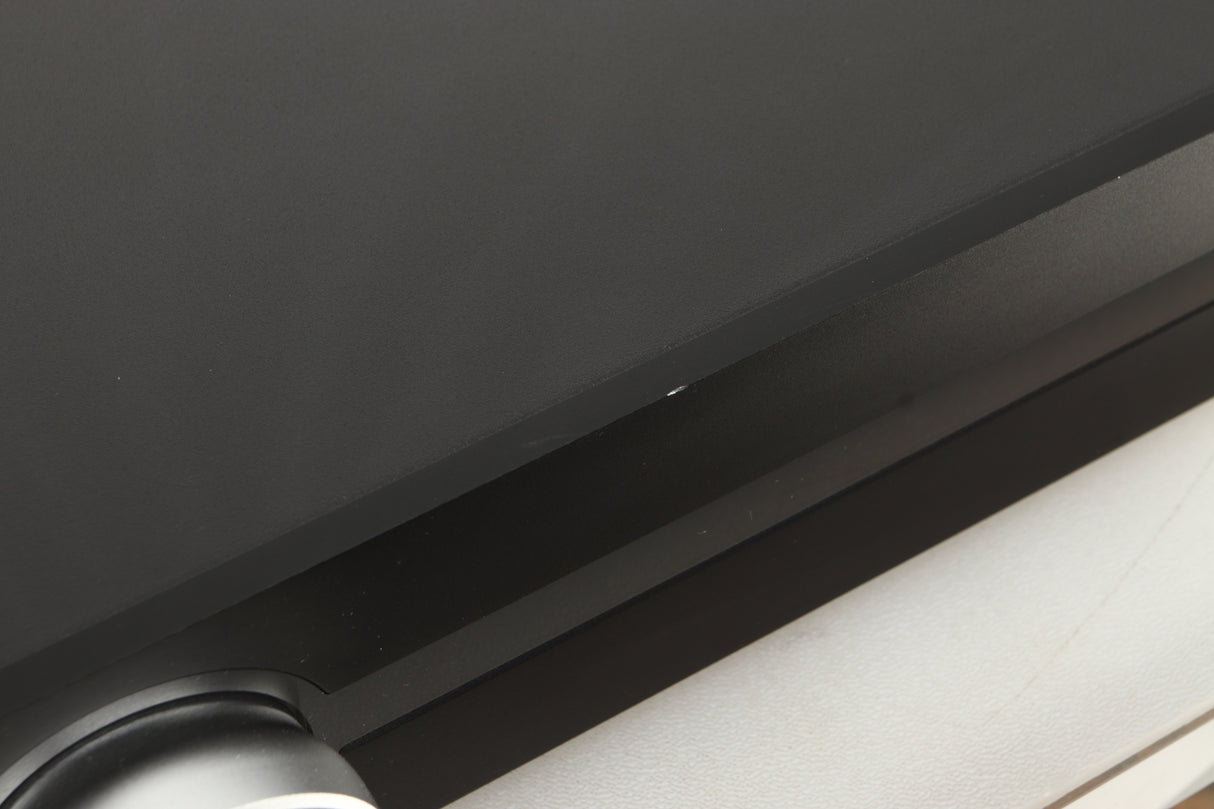 Close up view of a used Roksan Attessa Integrated Amplifier in Black finish showing a small chip on the front edge
