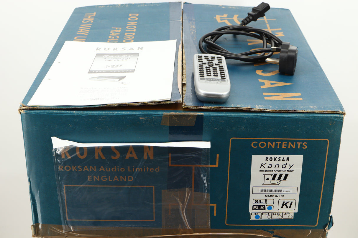 Box of a used Roksan Kandy KA-1 MkIII Integrated Amplifier in Black finish showing manual, mains cable, and remote