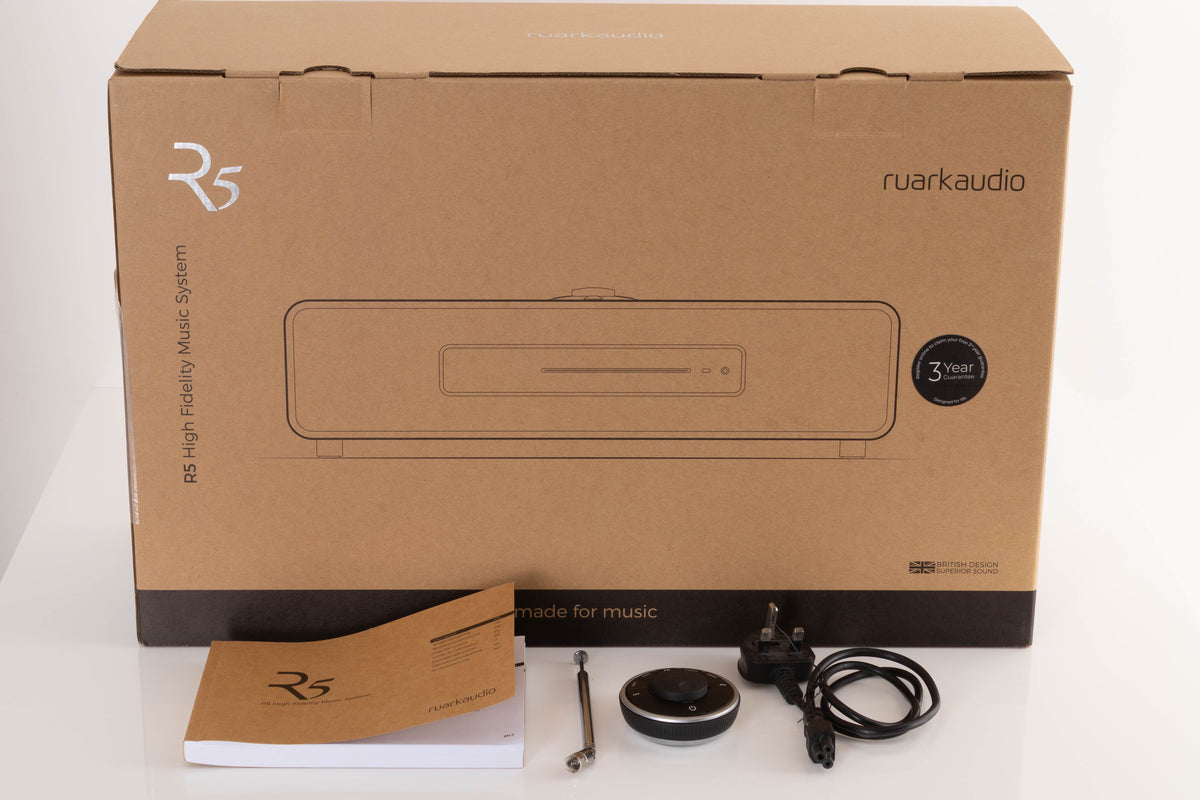 Box of a used Ruark R5 Music System in Soft Grey with mains cable, remote, manual, and antenna