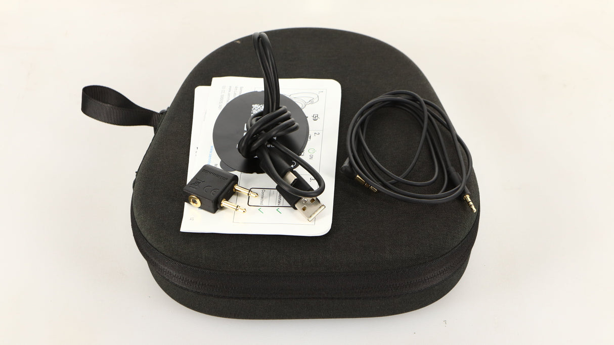 Case for used Sennheiser Momentum 4 Wireless Headphones in a black finish showing Manual, USB Cable, Adaptor and AUX Cable