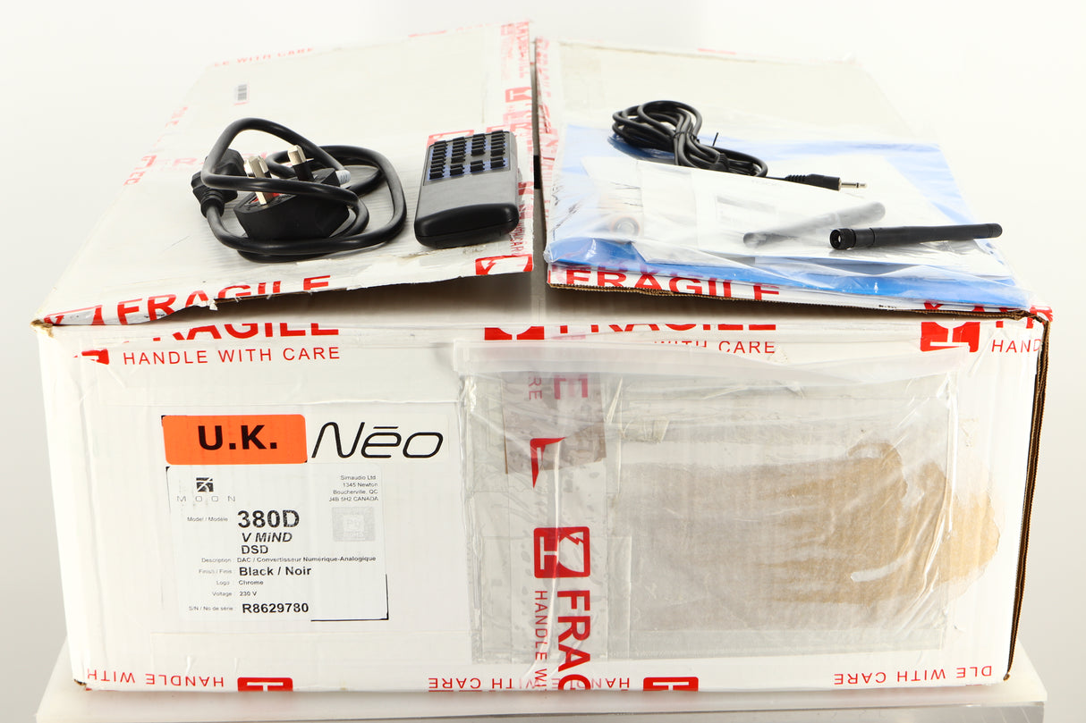 Box of a used Sim Audio Moon NEO 380D Mind 2 Streamer/DAC in Black finish with mains cable, manual, remote, 2x antenna, and 3.5mm cable