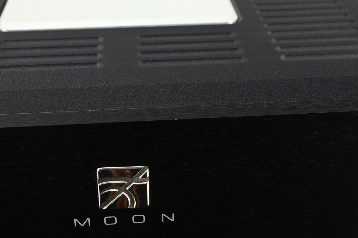 Close up view of a used Simaudio Moon 860A V2 Power Amplifier in black finish showing and small scratch on the front edge above the emblem