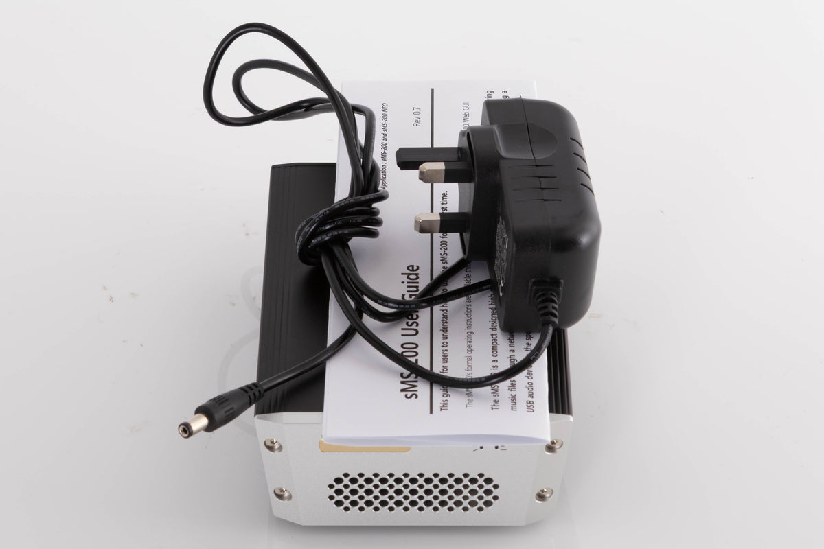 Top of a used SOtM SMS-200 Network Player showing PSU and Manual