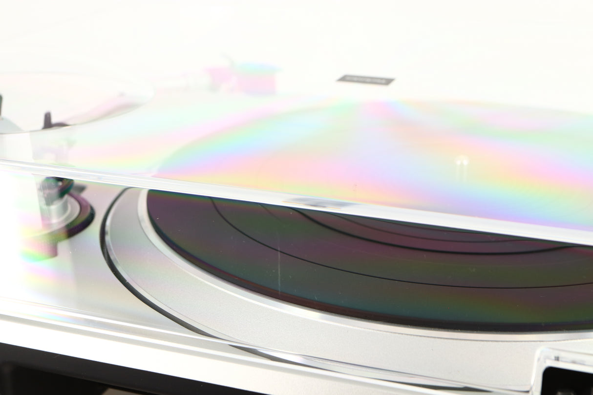Close up of a used Technics SL-1500C Turntable in a silver finish showing scratch on rear of lid