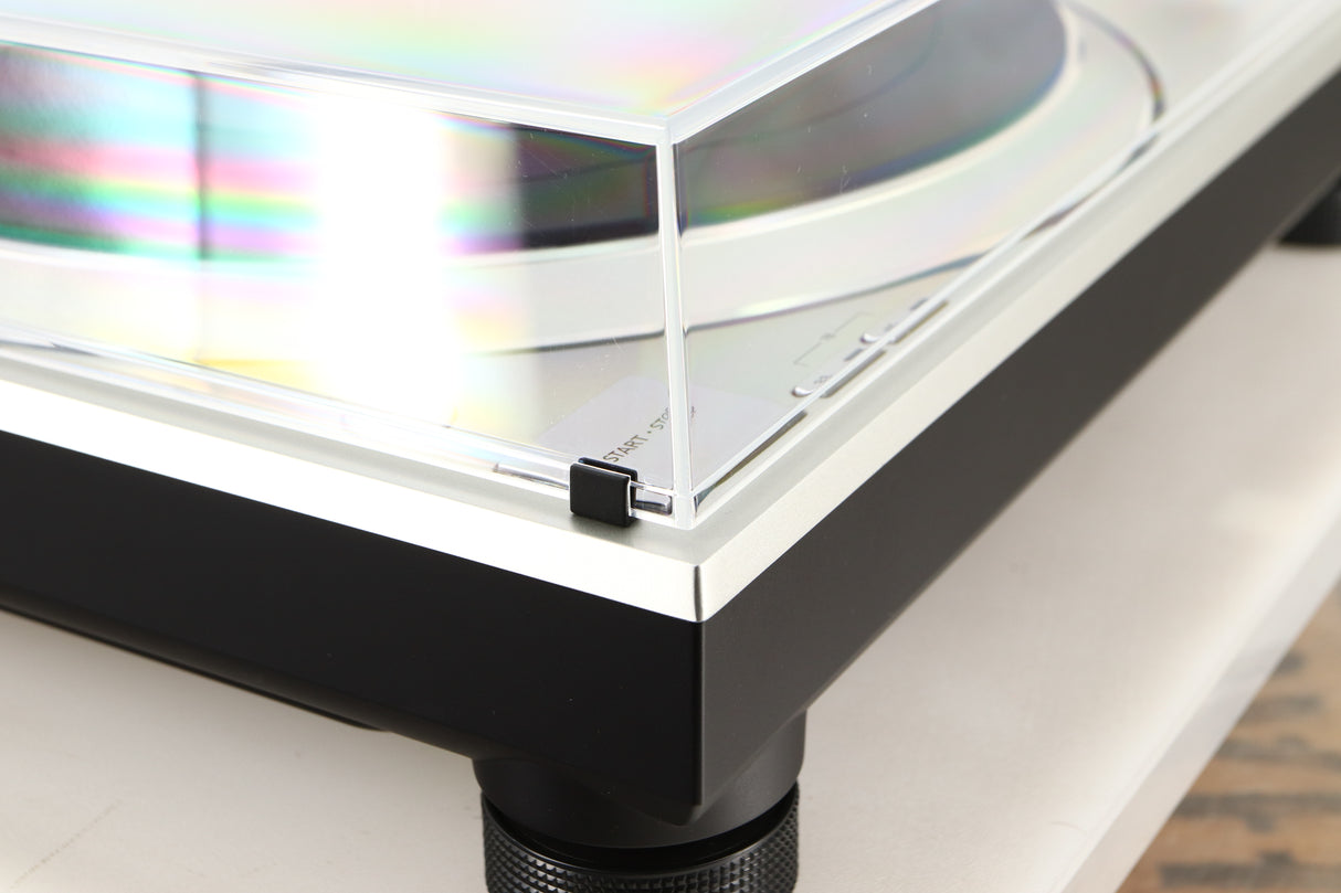 Front left corner of a used Technics SL-1500C Turntable in a silver finish