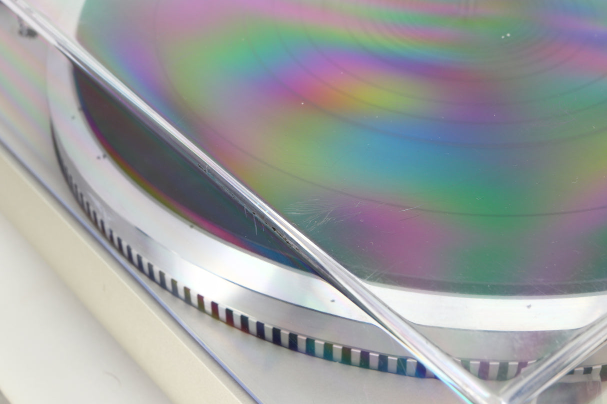 Close up view of a used Technics SL-Q2 Direct Driver Turntable in Silver showing some scratching on the lid