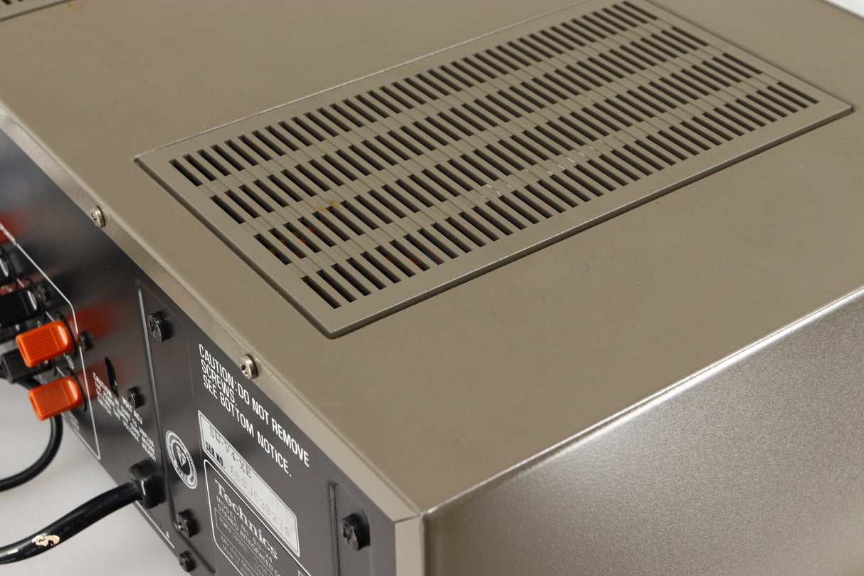 Close up of a used Technics SU-V4 Integrated Amplifier in a silver finish showing marks on top