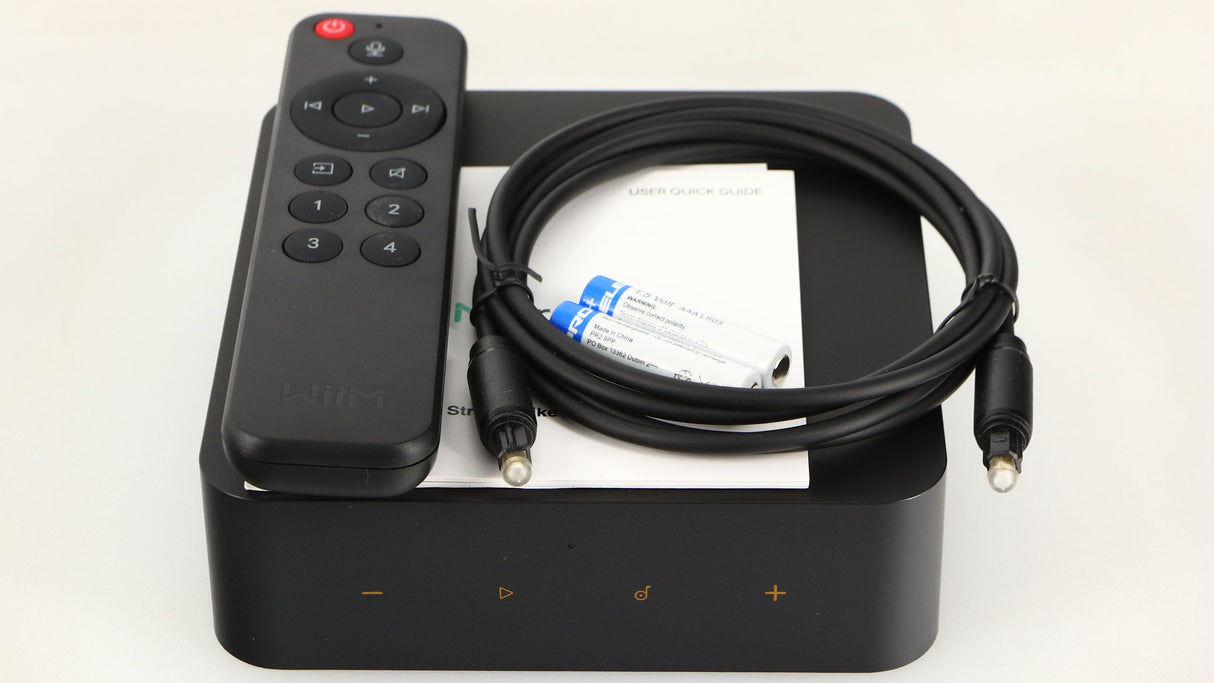 Top of a used Wiim Pro Plus Streamer in a black finish showing Manual, Remote, 2x Batteries and Optical Cable