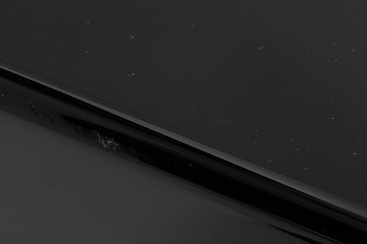 Close up of a used XTZ SA-1 Subwoofer in a Gloss Black finish sowing scratching on rear edge