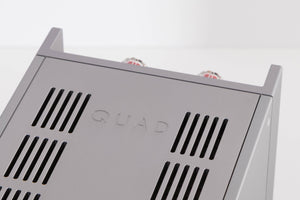Close up of a used Quad 303 Power Amplifier in a Silver finish showing logo on top
