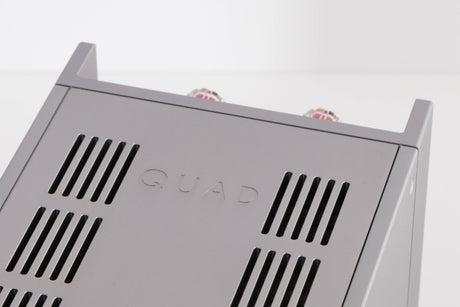 Close up of a used Quad 303 Power Amplifier in a Silver finish showing logo on top