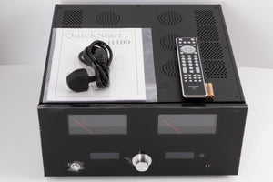 Top of a used Advanced Paris X-i1100 Integrated Amplifier in a Black finish showing Manual, Mains Cable, Remote and Batteries