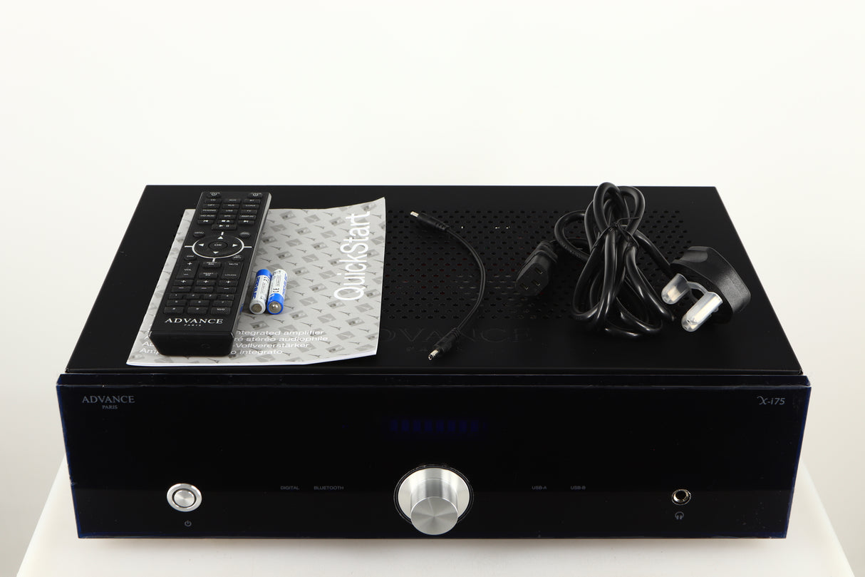Top of a used Advanced Paris X-i75 Integrated Amplifier in a black finish showing Remote 2x Batteries, Manual and Mains Cable