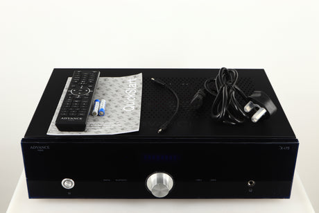 Top of a used Advanced Paris X-i75 Integrated Amplifier in a black finish showing Remote 2x Batteries, Manual and Mains Cable