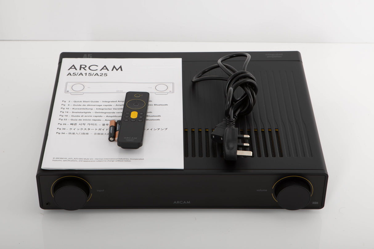 Top of a used Arcam A5 Integrated Amplifier in a black finish showing Remote, Batteries, Mains Cable and Manual