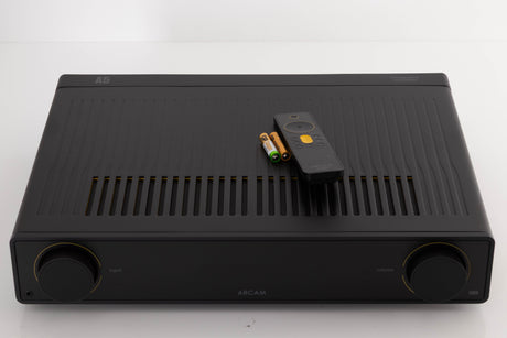 Top of a used Arcam A5 Integrated Amplifier in a Black finish showing Remote and Batteries