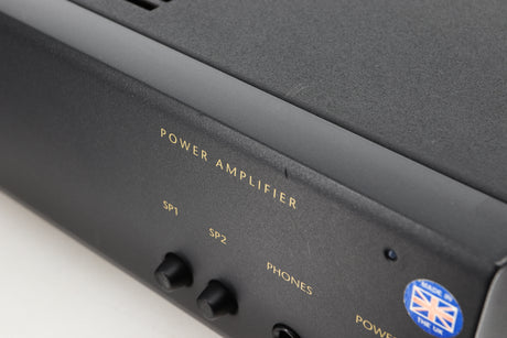 Close up view of a used Arcam Alpha 10 Power Amplifier showing scratching on the fascia and edge
