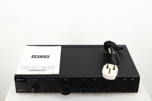 Top of a used Arcam Alpha 5 Plus Integrated Amplifier in a black finish showing Manual and Mains Cable