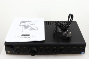 Top of a used Arcam Alpha 8R Integrated Amplifier in a black finish showing Manual and Mains Cable
