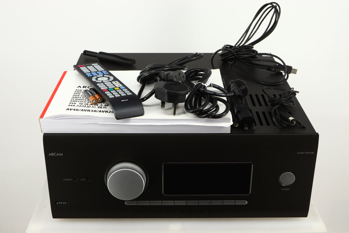 Top of a used Arcam AVR30 AV Amplifier in a grey finish showing Mains Cable, Schuko Cable, USB Cable, Manual, Remote, 2x Batteries, 2x Wi-Fi Aerials, Bluetooth Aerial, Set-Up MIC and Adaptor