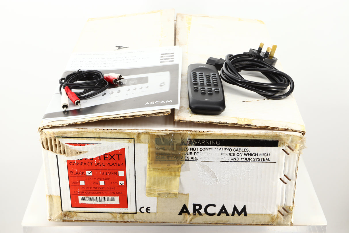 Box of a used Arcam CD73T CD Player in Black finish showing manual, mains cable, remote, and interconnects