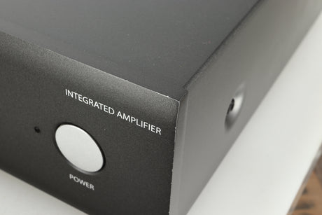 Close up view of a used Arcam SA30 Integrated Amplifier showing scratching on the edges around the corner 