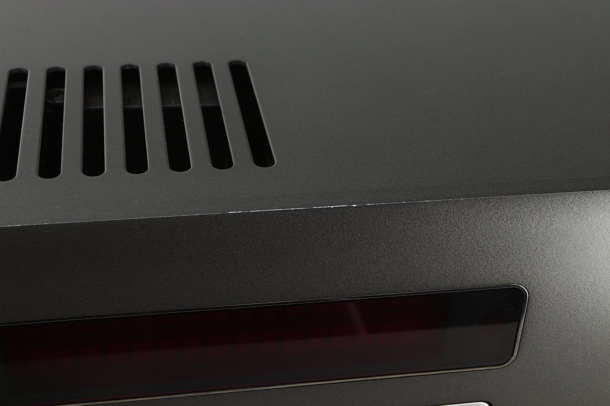 Close up view of a used Arcam SA30 Integrated Amplifier showing scratching on the top edge of the fascia