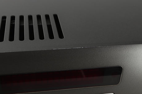 Close up view of a used Arcam SA30 Integrated Amplifier showing scratching on the top edge of the fascia