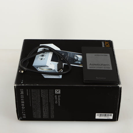 Box for a used Astrell & Kern Acro CA1000 Headphone Amplifier in a silver finish showing Manual and USB Cable