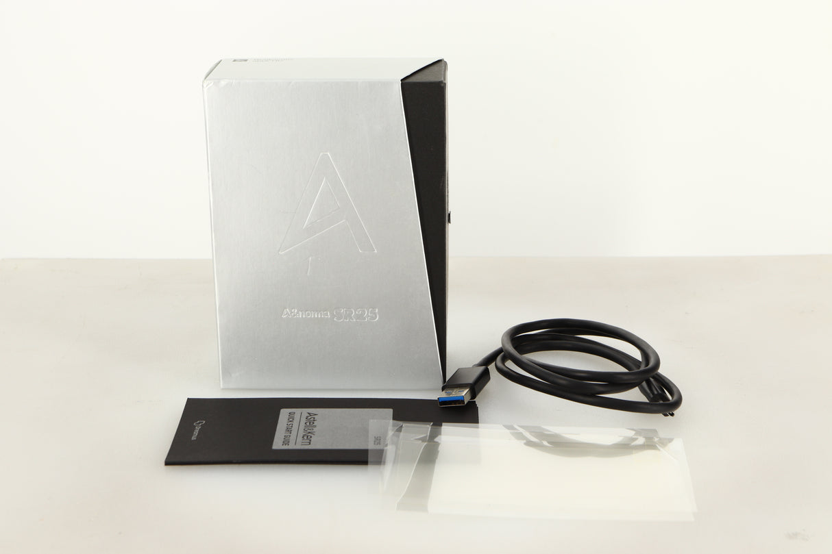 Box of a used Astell & Kern SR25 64gb Player in Silver finish showing USB cable, manual, and screen protectors