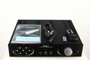 Top of a used Astin Trew AT2-2100 Integrated Amplifier in a black finish showing Manual, Mains Cable, Remote and 2x Batteries