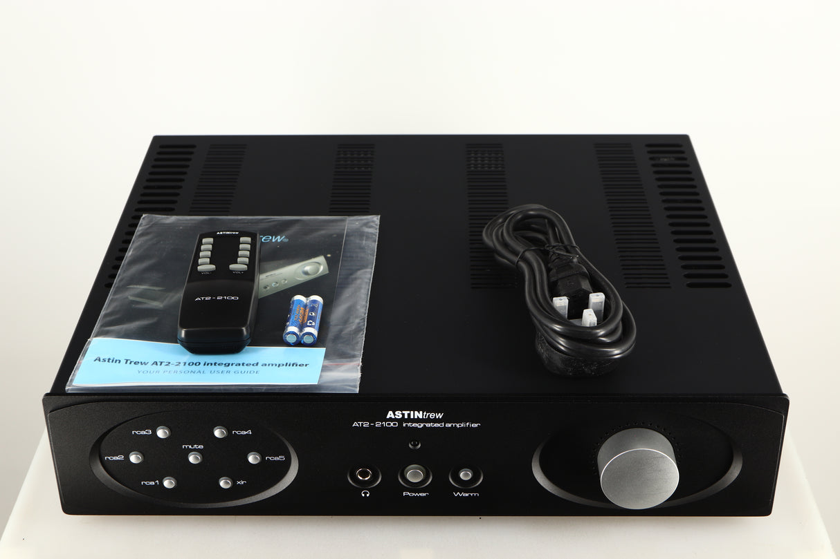 Top of a used Astin Trew AT2-2100 Integrated Amplifier in a black finish showing Remote, Manual, Mains Cable and Batteries
