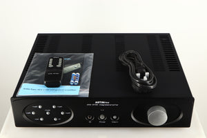 Top of a used Astin Trew AT2-2100 Integrated Amplifier in a black finish showing Remote, Manual, Mains Cable and Batteries