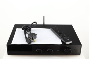 Top of a used Audiolab 9000A Integrated Amplifier in a black finish showing Mains Cable, Manual and Remote