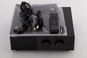 Top of a used Audiolab D9 Digital Analogue Converter in a Black finish showing Manual, Remote, Batteries, Mains Cable and USB Cable
