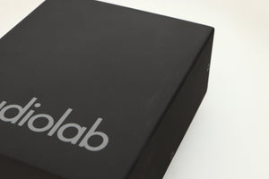 Close up view of a used Audiolab DC Block Mains Filter in Black finish showing light scratching on the top