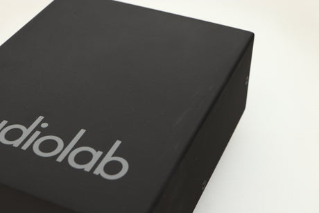 Close up view of a used Audiolab DC Block Mains Filter in Black finish showing light scratching on the top