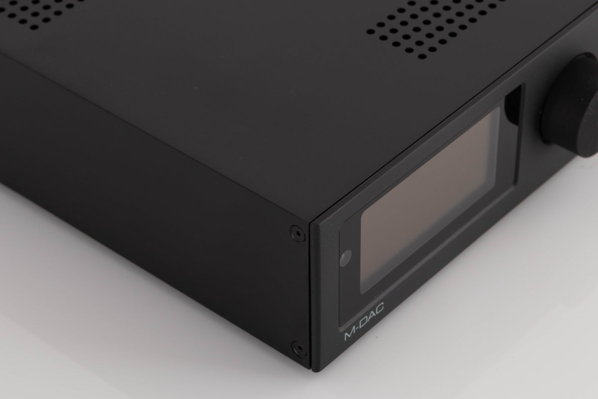 Front left corner of a used Audiolab M-DAC Digital Analogue Converter in a Black finish
