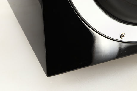 Close up of a used B&W ASW10CM Subwoofer in a gloss black finish showing scratching on fascia