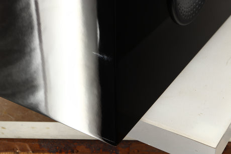 Close up of a used B&W CM Centre 2 Centre Speaker in a black gloss finish showing scratching on rear right corner