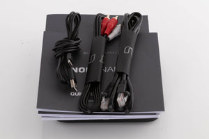 Top of a used Bluesound Node Nano Streamer in a Black finish showing Manual, USB Cable, Ethernet Cable and Interconnect Cable