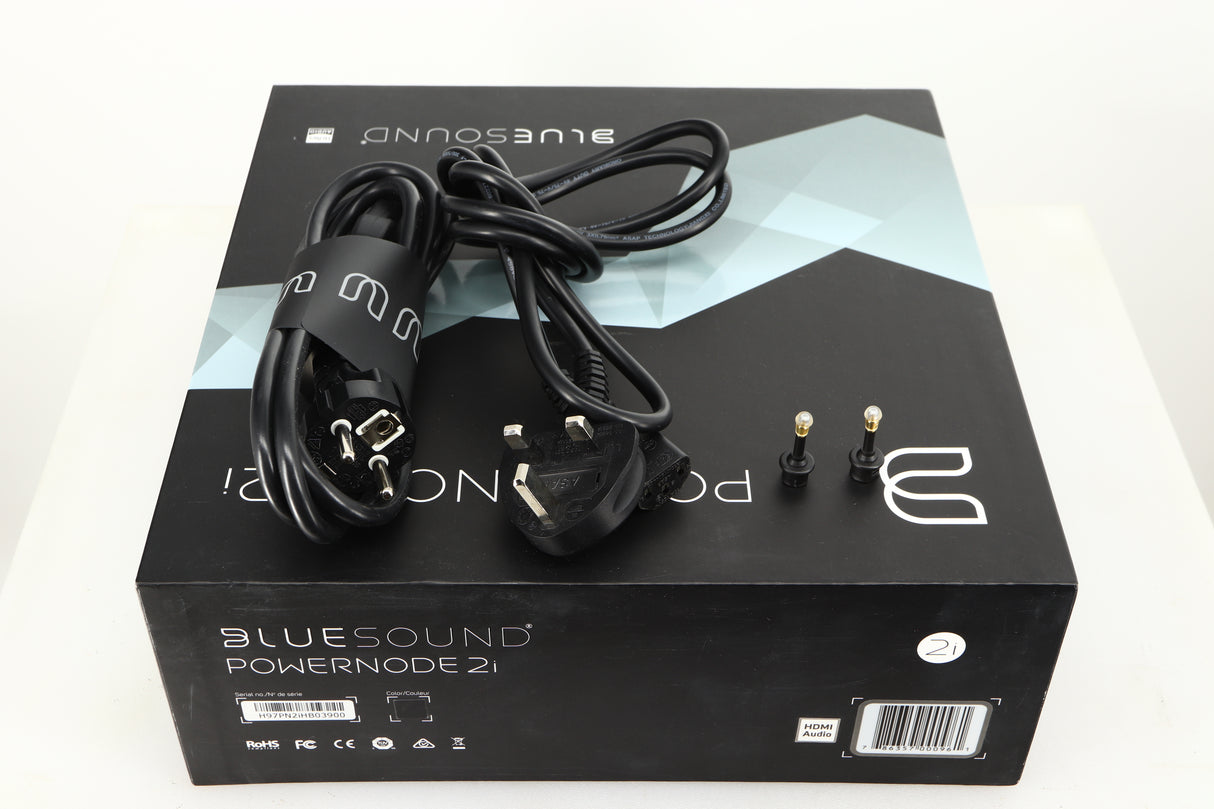 Box for a used Bluesound Powernode 2i Streaming Amplifier in a black finish showing Schuko Cable and Mains Cable