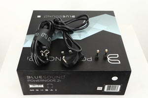 Box for a used Bluesound Powernode 2i Streaming Amplifier in a black finish showing Schuko Cable and Mains Cable