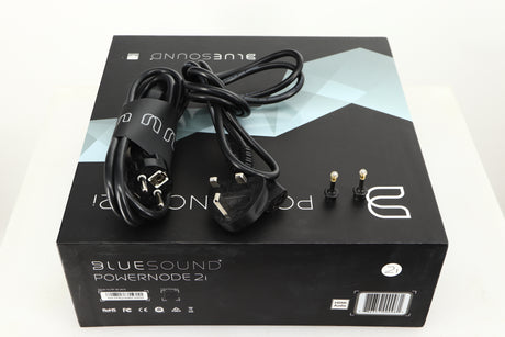 Box for a used Bluesound Powernode 2i Streaming Amplifier in a black finish showing Schuko Cable and Mains Cable