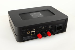 Close up of a used Bluesound Powernode 2i Streaming Amplifier in a black finish showing marking on the rear