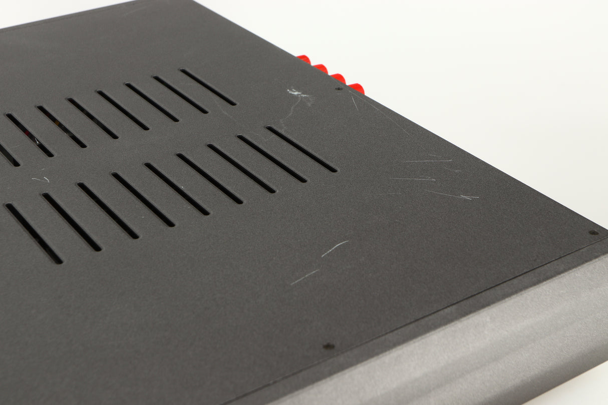 Close up of a used Cambridge Audio 340A Integrated Amplifier in a black finish showing scratching on top