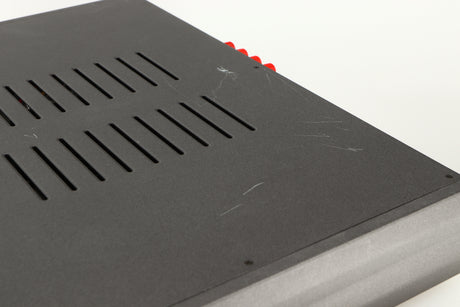 Close up of a used Cambridge Audio 340A Integrated Amplifier in a black finish showing scratching on top