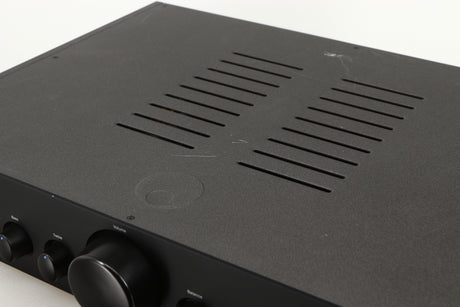 Close up of a used Cambridge Audio 340A Integrated Amplifier in a black finish showing scratching on top