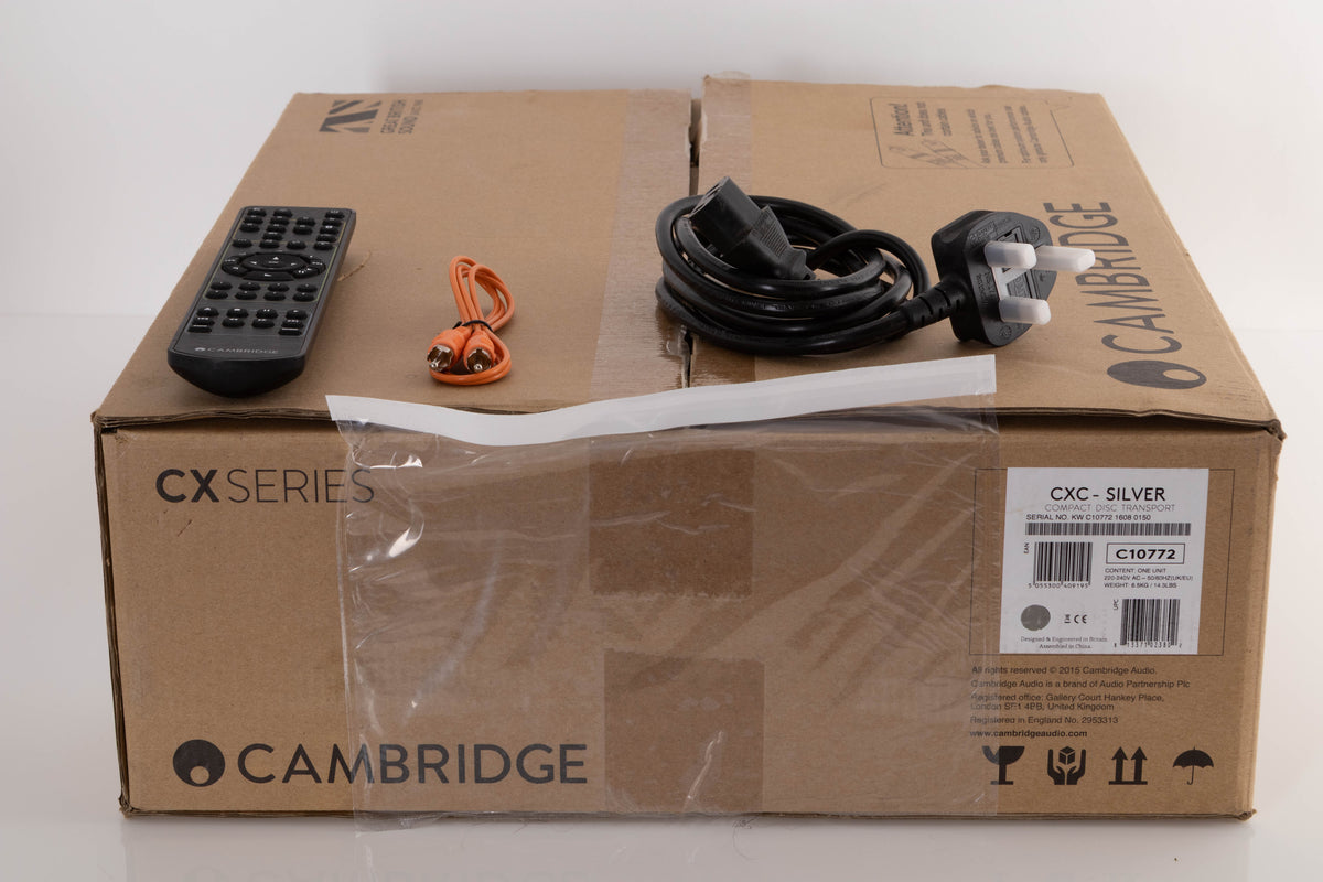 Box of a used Cambridge CXC CD Transport in Silver with mains cable, remote, and control bus cable