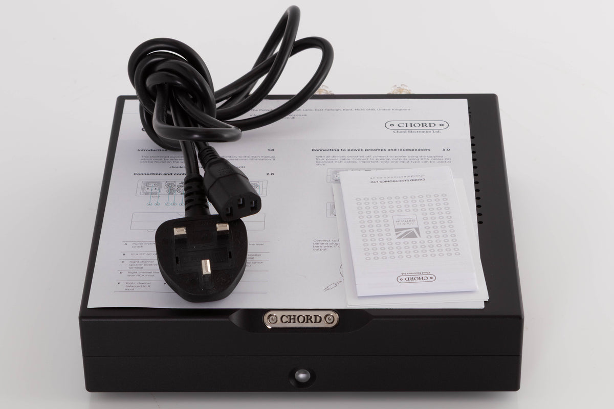 Top of a used Chord Electronics Bertti Power Amplifier in a Black finish showing Manual and Mains Cable